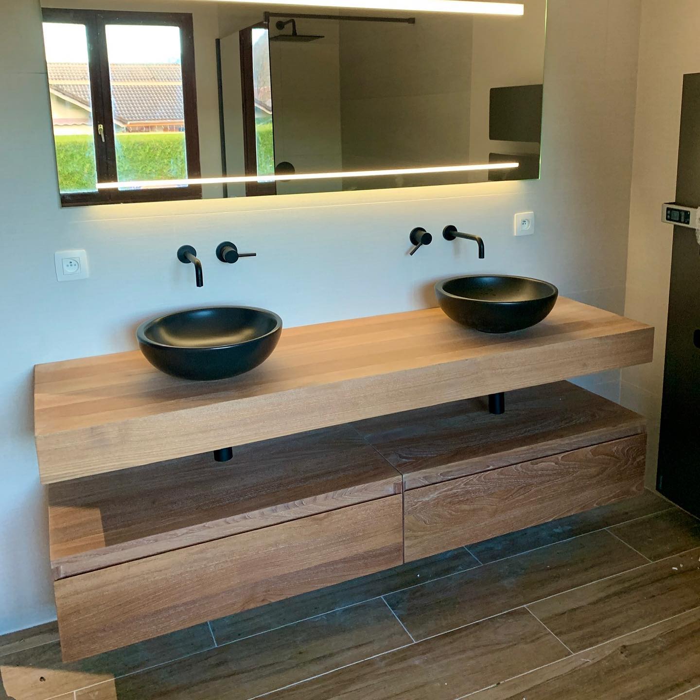 Photo de deux lavabos dans une salle de bain avec miroir lumineux