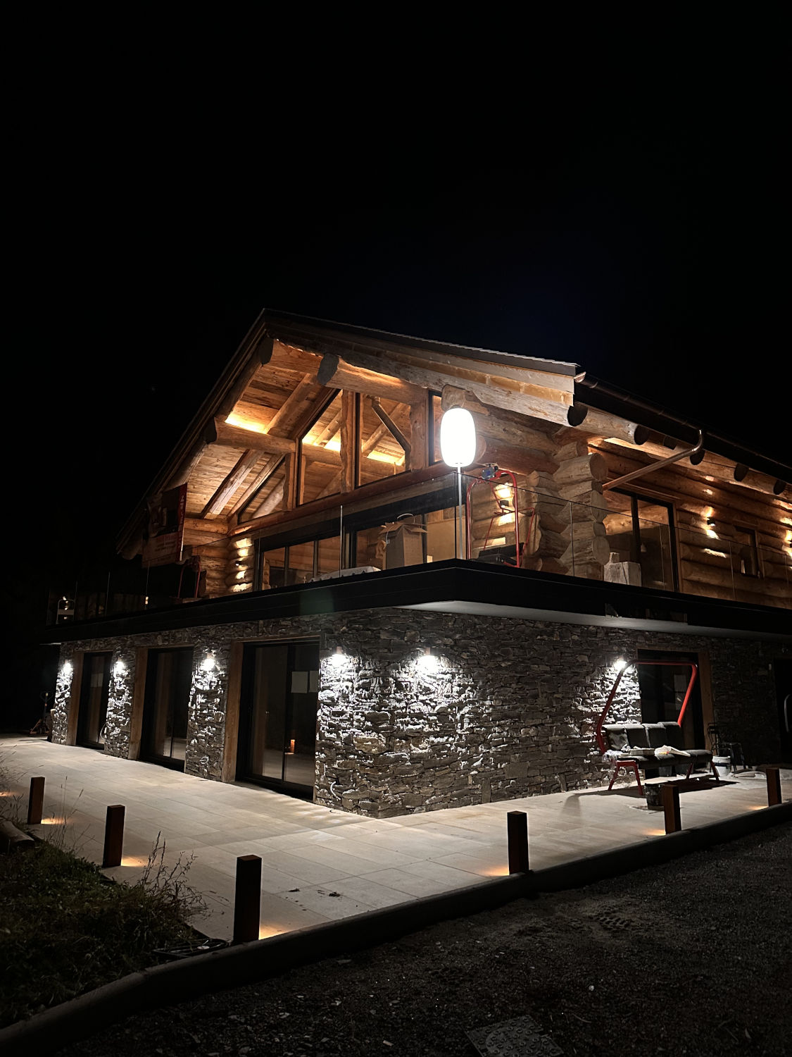 Photo de nuit de la construction et de l'aménagement extérieur d'un chalet dans la vallée de l'Arve en Haute-Savoie